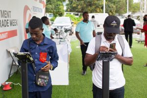 Two men using digital devices outdoors.